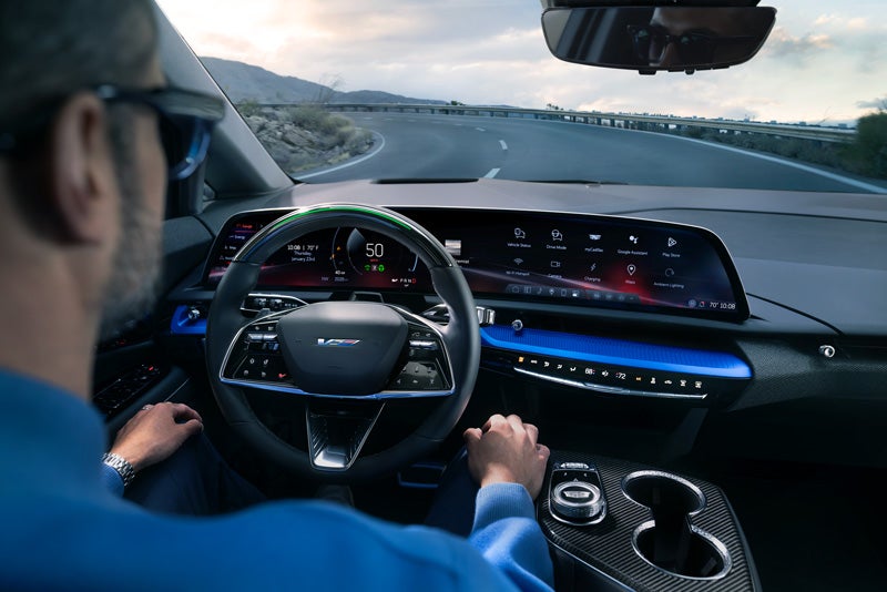 Front View of the 2026 OPTIQ-V Driving Through the Dusk Utilizing its Headlights | Open Road Cadillac of Morristown in Florham Park NJ